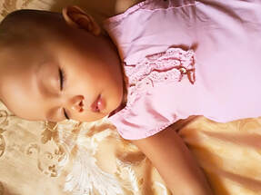 Close-up of girl baby of color sleeping peacefully with soft instrumental lullabies playing in the background